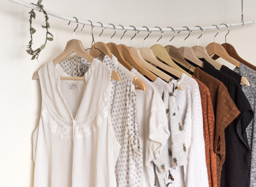 Women’s blouses hanging in small retail store.